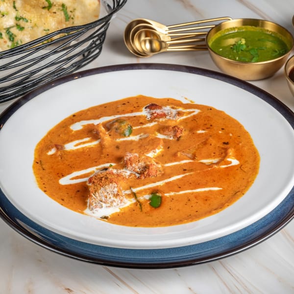 Ashoka Indian Restaurant's butter chicken with naan bread and green chutney.