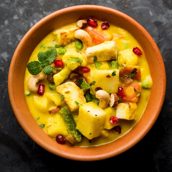 Ashoka Indian Restaurant's Navratan Korma, a creamy yellow curry with paneer, vegetables, nuts, and pomegranate seeds.