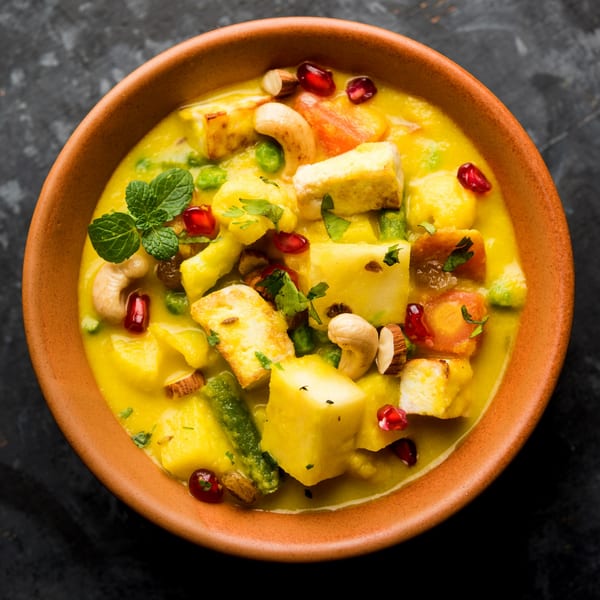 Ashoka Indian Restaurant's Navratan Korma, a creamy yellow curry with paneer, vegetables, nuts, and pomegranate seeds.
